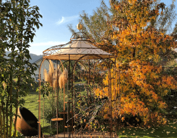 Pavillon Siena in unbeschichtet mit Sonnensegel und Messingkugel in einm herbstlichen Garten