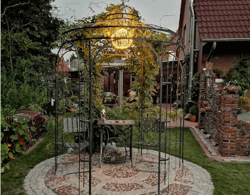 Pavillon Siena in pulverbeschichteter Ausfuehrung beleutet in einem Garten