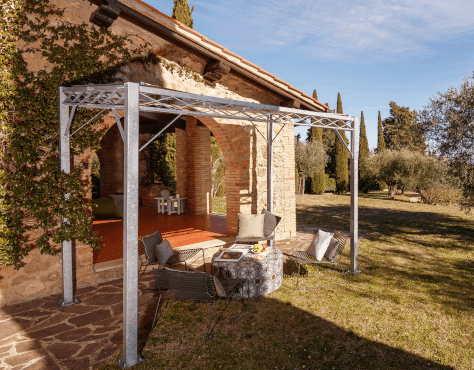 Pergola Ischia in feuerverzinkt mit Sonnensegel an Terrasse angestellt mit Sitzgelegenheiten zum Entspannen